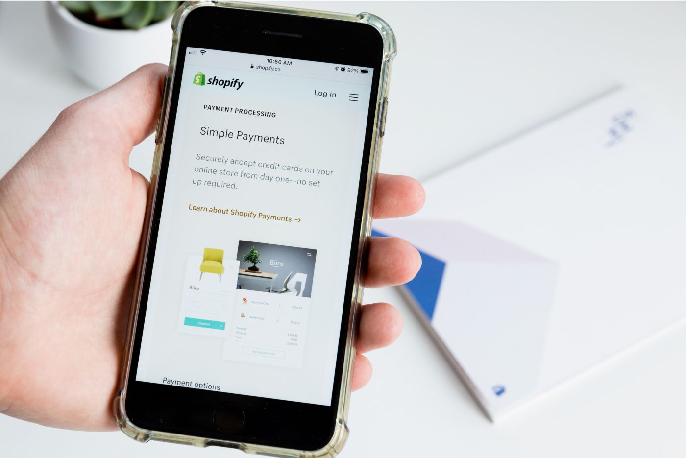 Image of a phone with Shopify content on screen.
