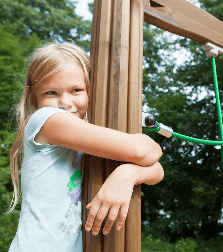 Child leaning on a wooden post