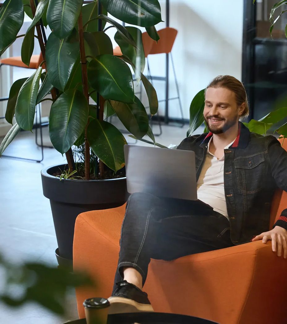 Man sitting on chair looking at laptop