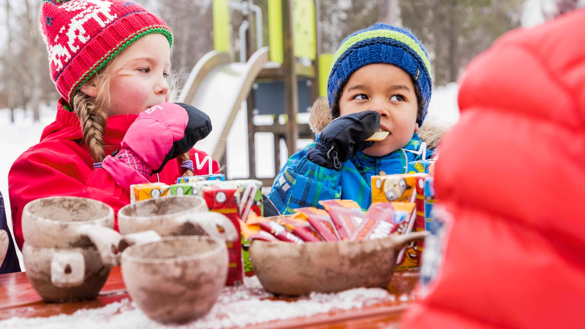 Children eating on playground in the winter
